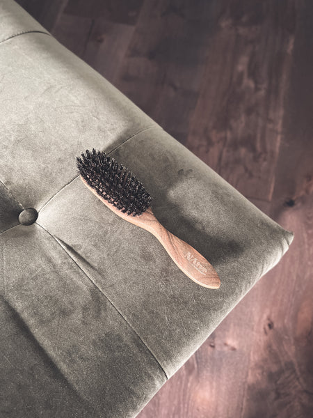 Wooden boar bristle beard brush on a modern couch